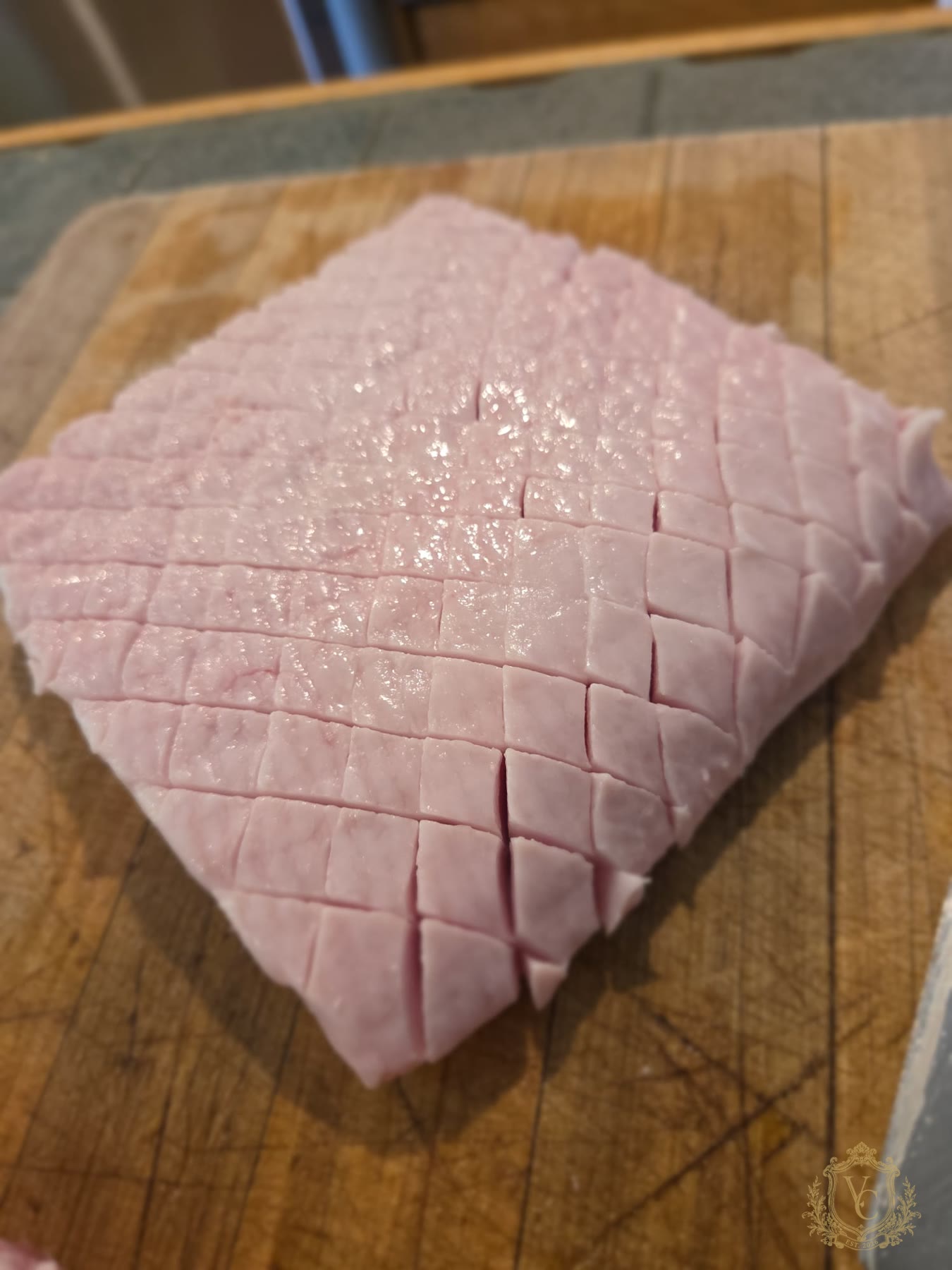 Raw pork belly scored in a diamond pattern before searing.