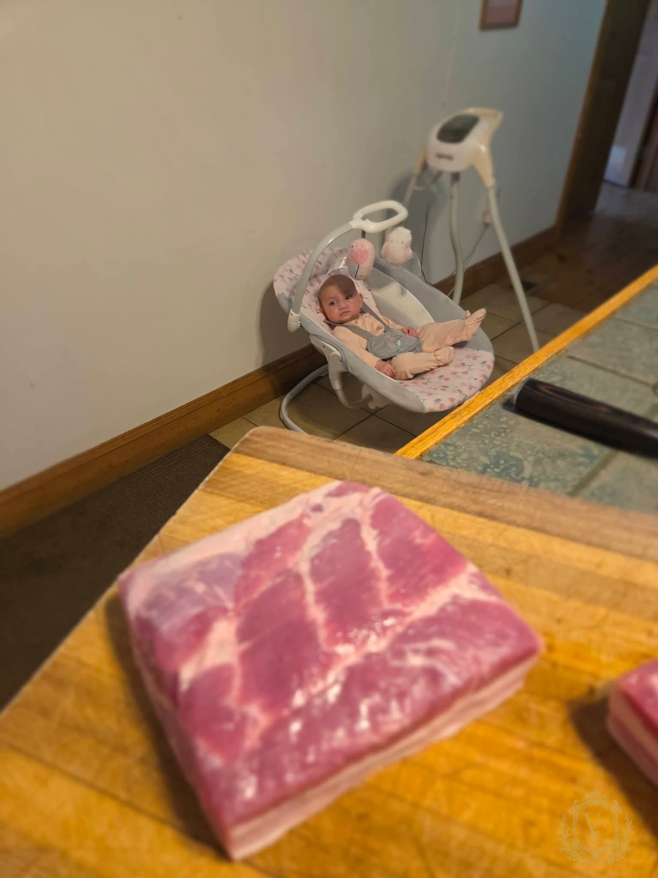 Raw pork belly on Steven Calabrese kitchen counter with baby Vera in the background.